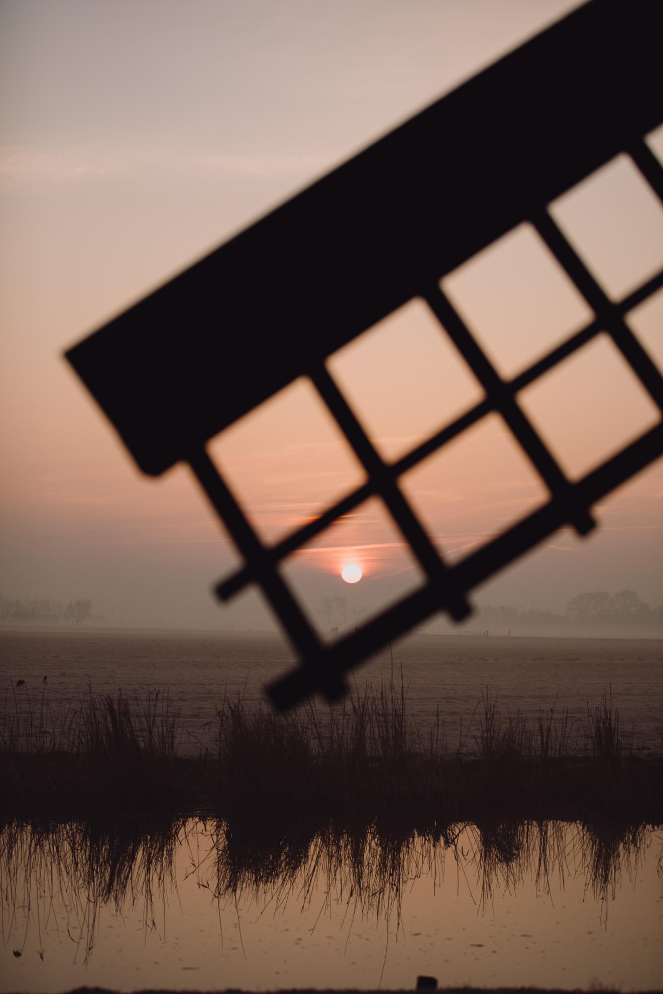Opkomende rode zon in Broek in Waterland door molenwiek