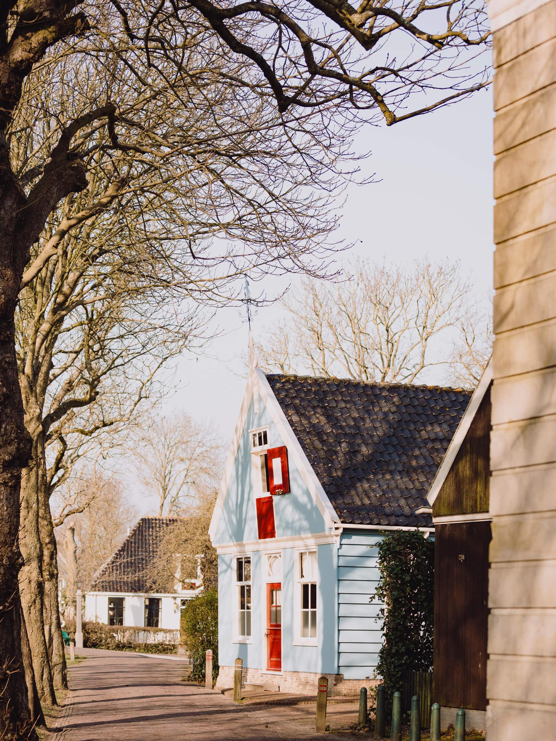 Authentiek Broeker grijzen huis met overhangende bomen en schaduw naast Het Broeker Huis op het Leeteinde