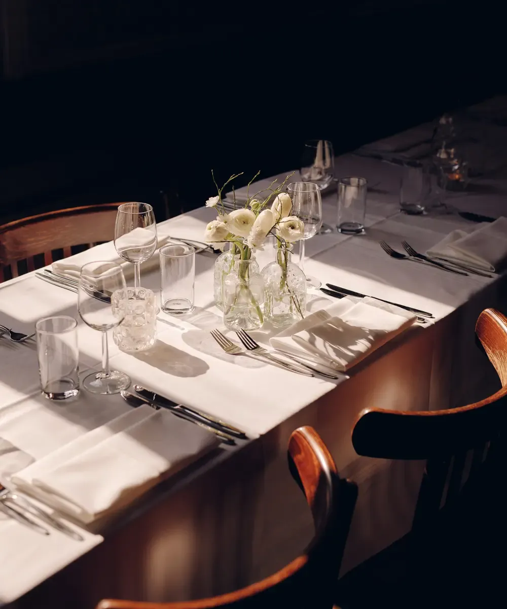 Gedekte dinertafel met bloemen in Grote Zaal van Het Broeker Huis