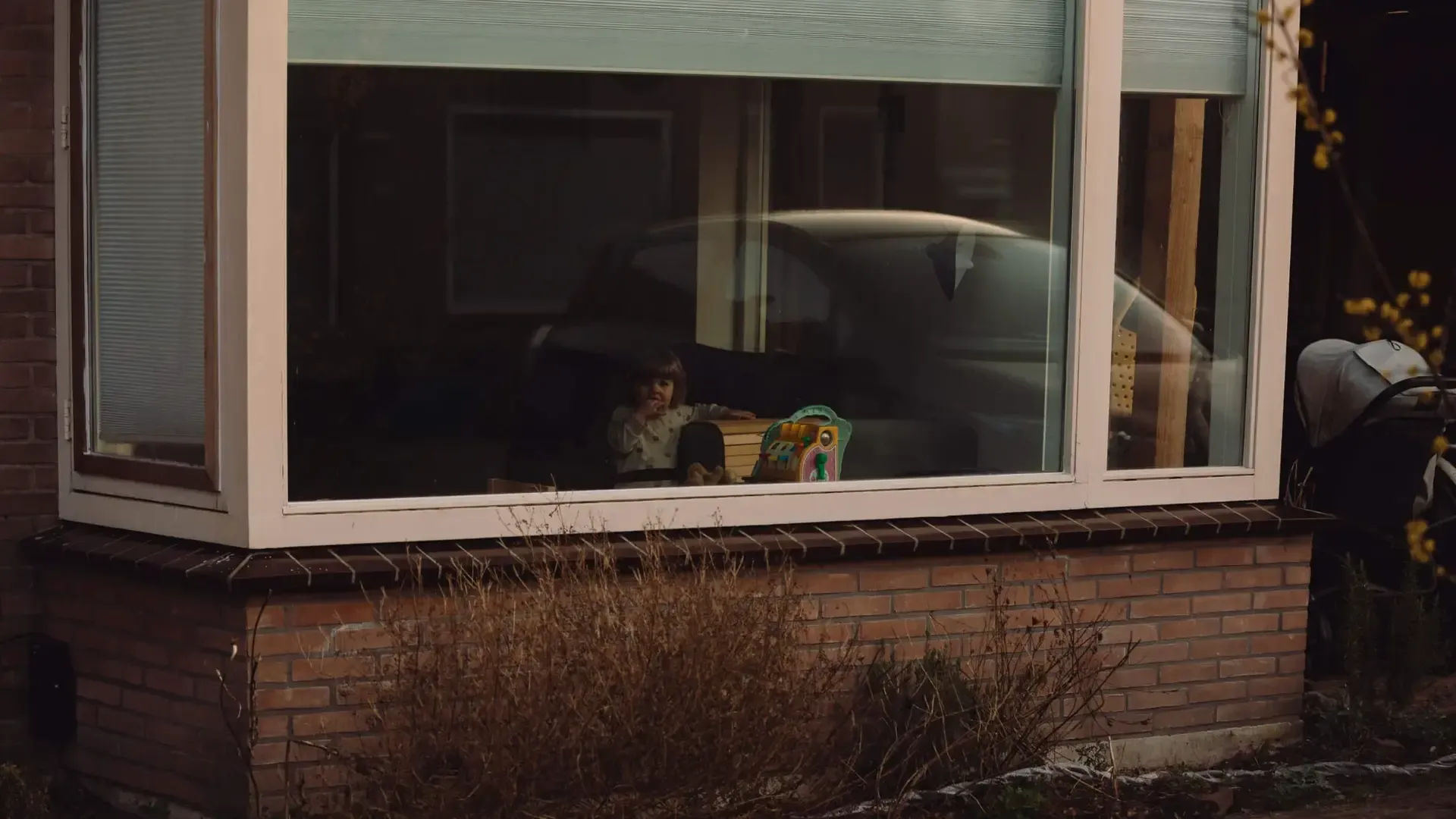 Kind speelt achter raam van houten huis in Broek in Waterland